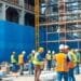 Bauarbeiter auf einer Baustelle mit Sicherheitsausrüstung.